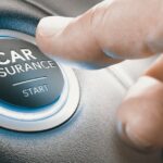 Close-up of a thumb leaning forward to press a glowing button in a car that reads "Car Insurance -- Start."