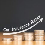 A car races towards stacks of coins on a wooden surface. An arrow sits above the coins and the words "Car insurance."