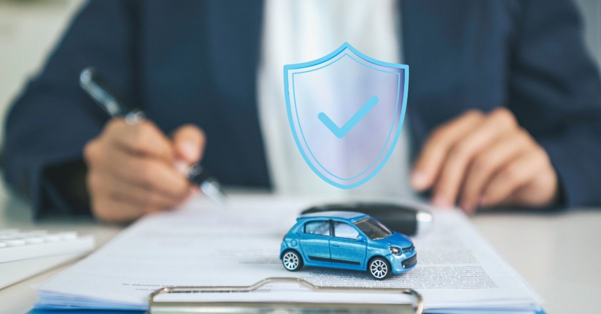 A person fills out paperwork on a clipboard. A toy car sits on the clipboard while a shield image sits above it.