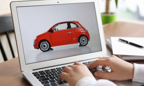 man on computer looking up car insurance