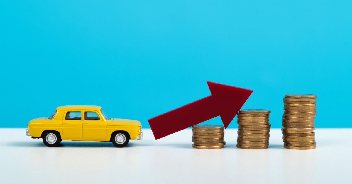 A small yellow toy car sits in front of a red arrow and stacks of coins. They are in front of a blue background.